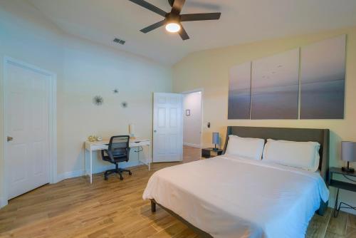 a bedroom with a bed and a desk and a ceiling fan at New Resort Style Oasis ~ LED Pool & Game Room in Minneola