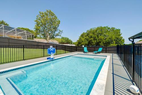 a swimming pool with two chairs and a fence at New Resort Style Oasis ~ LED Pool & Game Room in Minneola