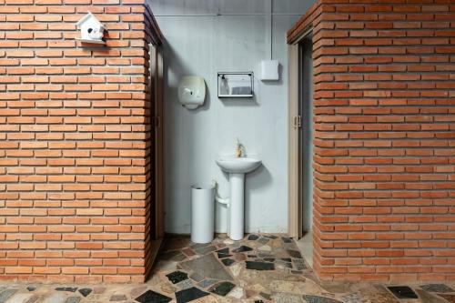 a bathroom with a sink in a brick wall at Quarto 03 Pousada Roosevelt in Uberlândia