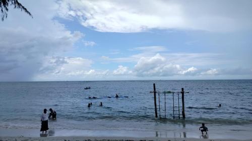 a group of people in the water at the beach at Madu Tiga Beach and Resort in Tanjung Pinang 