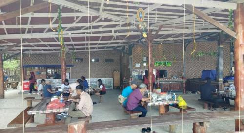 a group of people sitting at tables in a restaurant at Madu Tiga Beach and Resort in Tanjung Pinang 