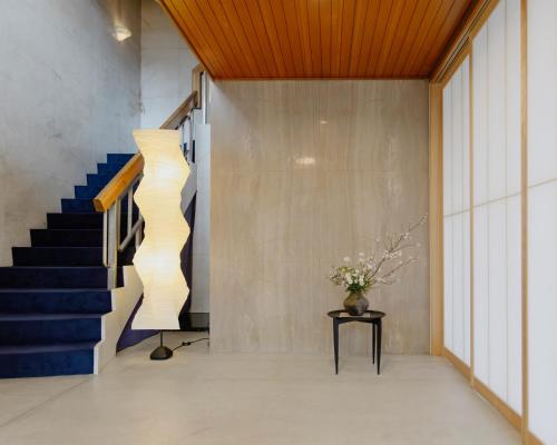 a staircase in a lobby with a vase of flowers at 穴吹邸 / ANABUKI-TEI in Takamatsu