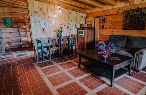 a living room with a couch and a table at Gîte de l'herboriste in Sainte-Rose-du-Nord