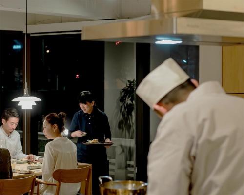 a group of people in a kitchen preparing food at 穴吹邸 / ANABUKI-TEI in Takamatsu
