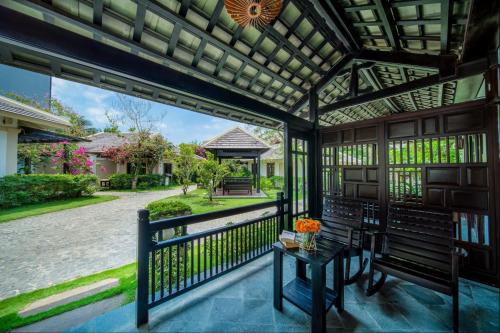 a screened in porch with a table and flowers on it at Anja Beach Resort & Spa in Phu Quoc