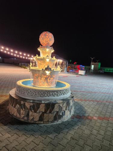 a fountain in the middle of a courtyard at night at Lina Dreamland Resort in Billah