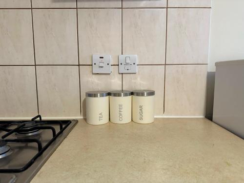três latas de lixo sentadas ao lado de um fogão numa cozinha em Wembley Stadium Serviced Apartment 2, 12mins to Central London em Londres