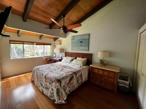 a bedroom with a bed and a ceiling fan at Modern Kahana getaway in Kahana