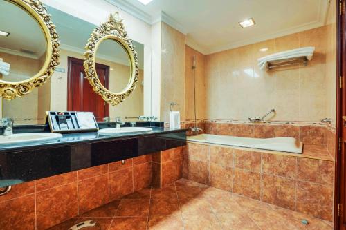 a bathroom with two sinks and a tub and a mirror at ABC Entertainment Resort in Angeles
