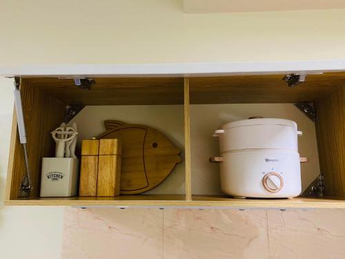 estantería con tostadora y otros artículos de cocina en Pauline's Getaway near Nuvali Paseo Santa Rosa en Bayabasan