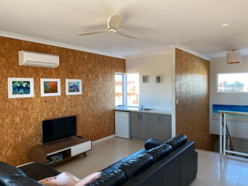 a living room with a couch and a tv at 35 Bluefin Cove in Exmouth