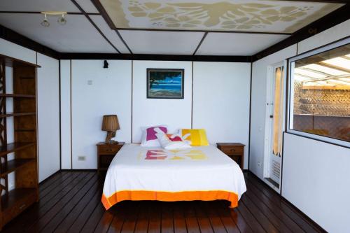 - une chambre avec un lit et une fenêtre dans l'établissement Maison d’hôtes bord de mer ia orana lodge, à Moorea