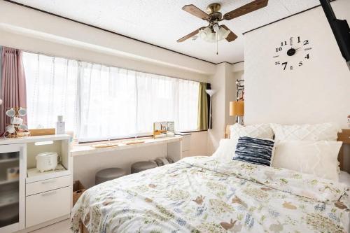 une chambre avec un lit et une horloge au mur dans l'établissement 201.Near Ueno Park/3min train St.Easx access, à Tokyo