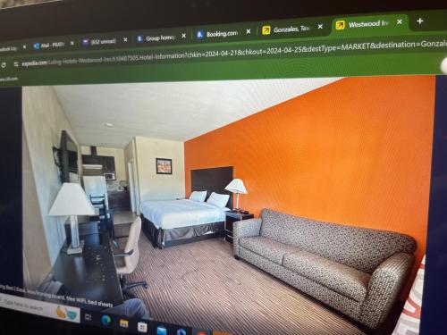 een hotelkamer met een bed en een bank bij westwood inn in Gonzales