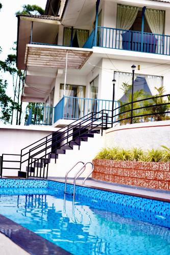 a swimming pool in front of a building at Paadi Holidays Ramakkalmedu in Idukki