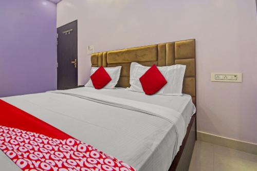 a bedroom with a large bed with red pillows at Hotel Krishna Palace in Jaipur