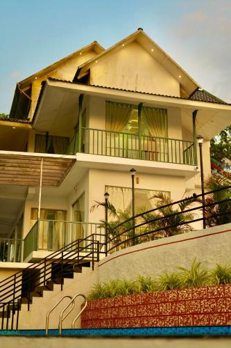 a house with a swimming pool in front of it at Paadi Holidays Ramakkalmedu in Idukki