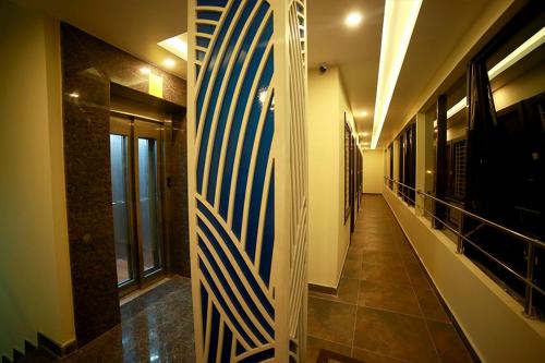 a hallway with a blue and white surfboard on the wall at SAPPHIRE INN in Puducherry