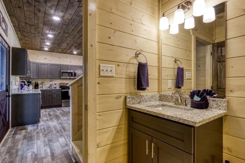 セバービルにあるAdventure Splash - Smoky Mountain Retreats Cabins with Private Indoor Pool, Hot Tubs & Fun!のシンクとカウンターのあるキッチン