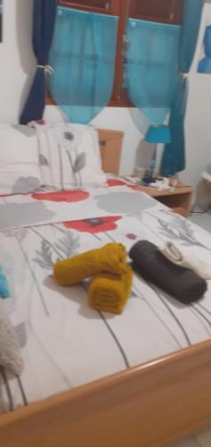 un letto con due guanti gialli sopra di Le p'tit nid cocodydy a Baillif