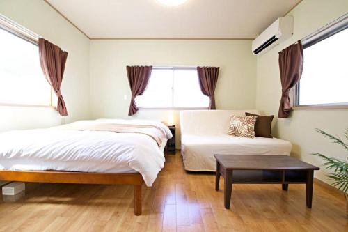 a bedroom with two beds and a table at 梅屋敷貸家 in Tokyo