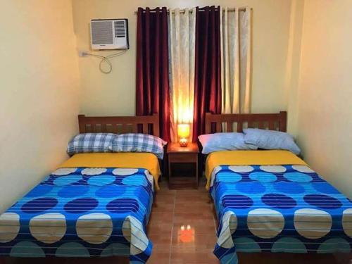 a room with two beds and a window at TGH Guest House Badian in Badian