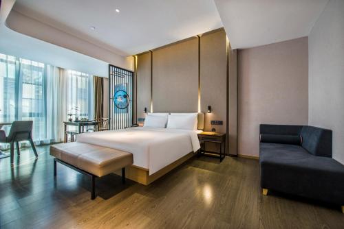 Habitación de hotel con cama y silla en Atour Hotel Dongguan Humen Avenue, en Dongguan