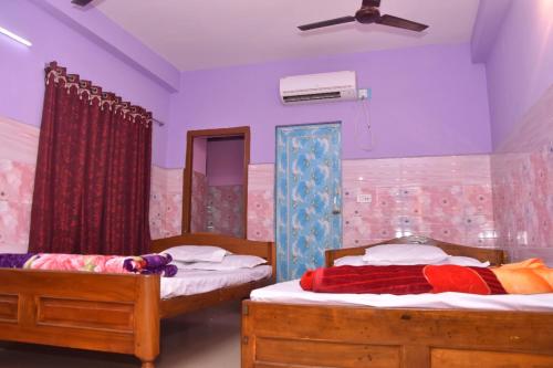 Hotel Milan Guest House Digha - Couple Friendly في ديغا: غرفة نوم بسريرين ومكيف