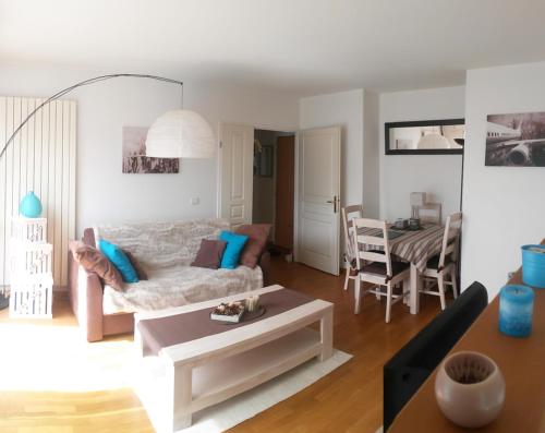 - un salon avec un canapé et une table dans l'établissement Calm appartment with its terrace, à Levallois-Perret