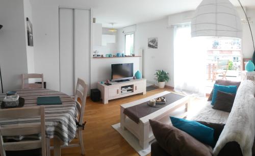 - un salon avec un canapé et une table dans l'établissement Calm appartment with its terrace, à Levallois-Perret