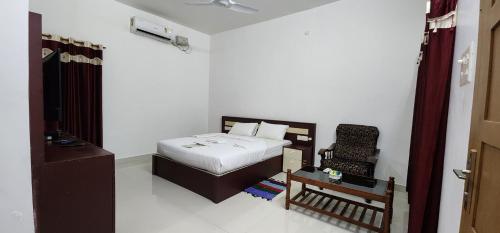 a small bedroom with a bed and a chair at Pepper and Clove Enclave in Puliyara