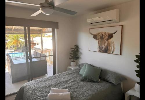 a bedroom with a bed with a picture of a cow on the wall at Bundalong Villas in Bundalong
