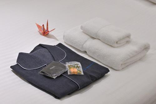 uma pilha de toalhas e uma bolsa sobre uma mesa em UNO HOTEL em Tamano