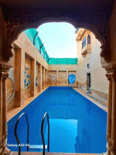 a swimming pool with blue water in a building at Hotel Tokyo Palace in Jaisalmer