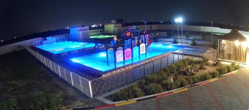 a swimming pool at night with blue lights at Lina Dreamland Resort in Billah
