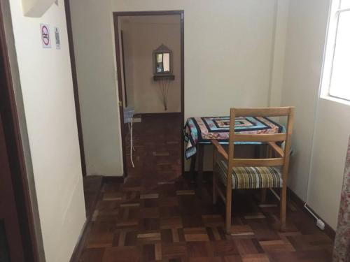 a hallway with a table and a chair in a room at Mi casa tu casa. My house in La Paz