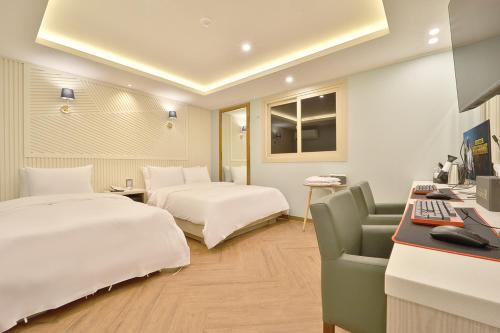 a hotel room with two beds and a desk at Deagu Hotel Rubato RB in Daegu