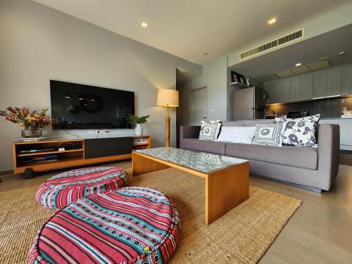 a living room with a couch and a table at Mountain View Suite at The Valley Khaoyai in Ban Huai Sok Noi