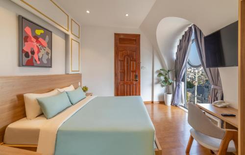 a bedroom with a large bed and a desk at Pham Gia Dalat Villa & Hotel in Da Lat