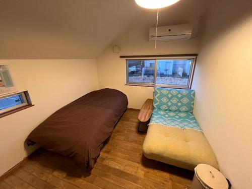 a small room with a bed and a couch at B&BHOUSE FAM in Ichinomiya