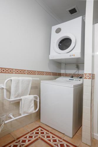 a bathroom with a washer and dryer in a room at Chic Princes Wharf Studio - City View - Parking in Auckland