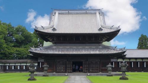 a large building with a roof with people standing in it at Toyoko Inn Shin takaoka eki Shinkansen Minami guchi in Takaoka