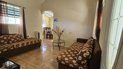 un soggiorno con 2 divani e un tavolo di Ocean View Apartment a Soufriere