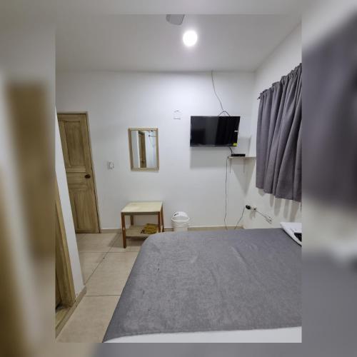 a bedroom with a bed and a tv on a wall at Hotel Miami center in Montería