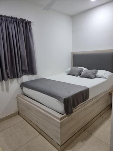 a bed in a white room with at Hotel Miami center in Montería