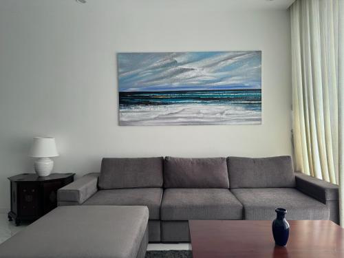 a living room with a couch and a painting of the ocean at Peak of Colombo in Colombo