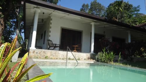 una casa con piscina frente a ella en Monkey manor villa, Strathisla Tea Estate Bungalow en Matale