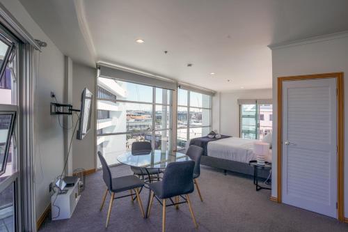 a bedroom with a bed and a table and chairs at Chic Princes Wharf Studio - City View - Parking in Auckland