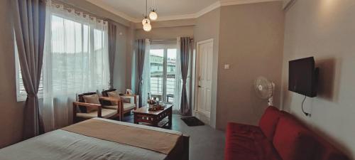 a bedroom with a bed and a chair and a window at Urban Tavern Shillong in Shillong