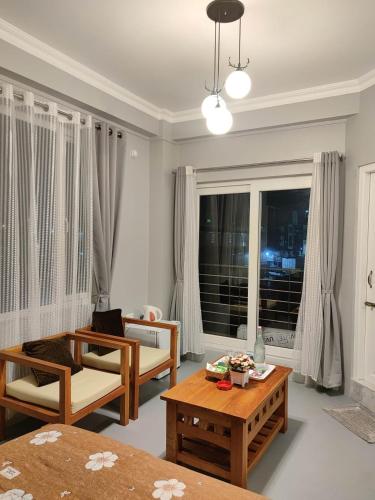 a living room with tables and chairs and a window at Urban Tavern Shillong in Shillong